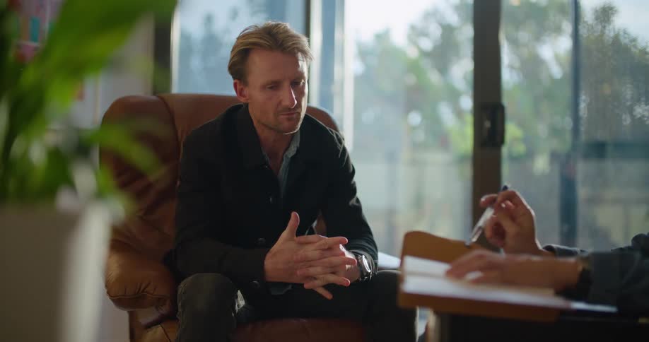 A man appears emotional as he talks during a meeting with another