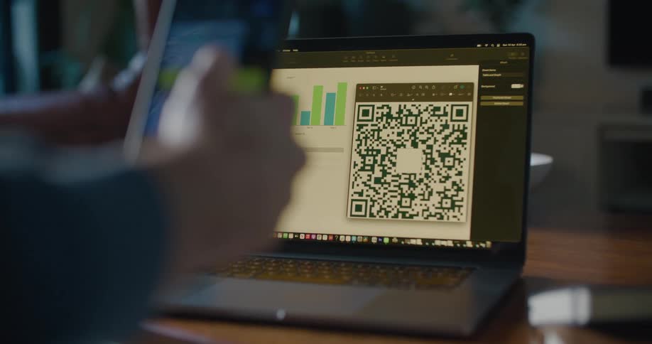 Someone uses their cell phone to take a picture of a code on a laptop computer screen