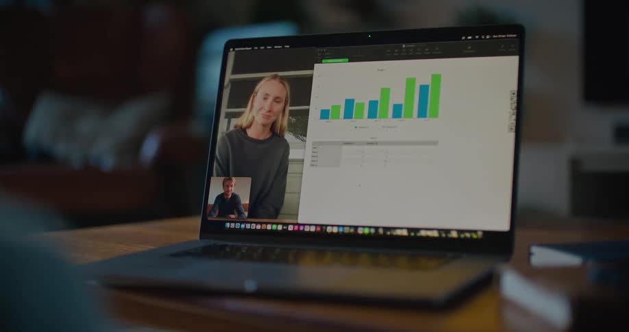 Male and female coworkers discuss chart via laptop video conferencing