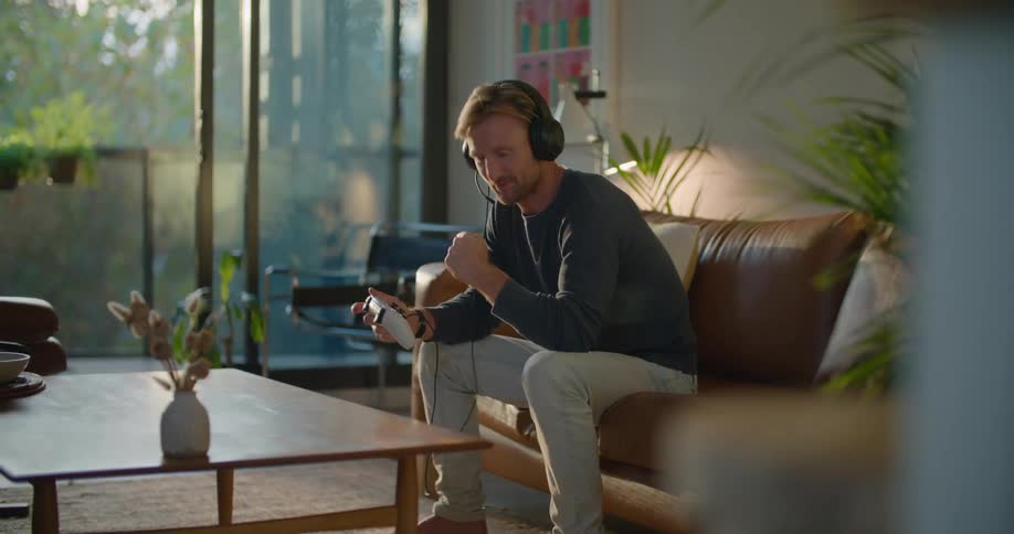 A man sitting in a room playing video games