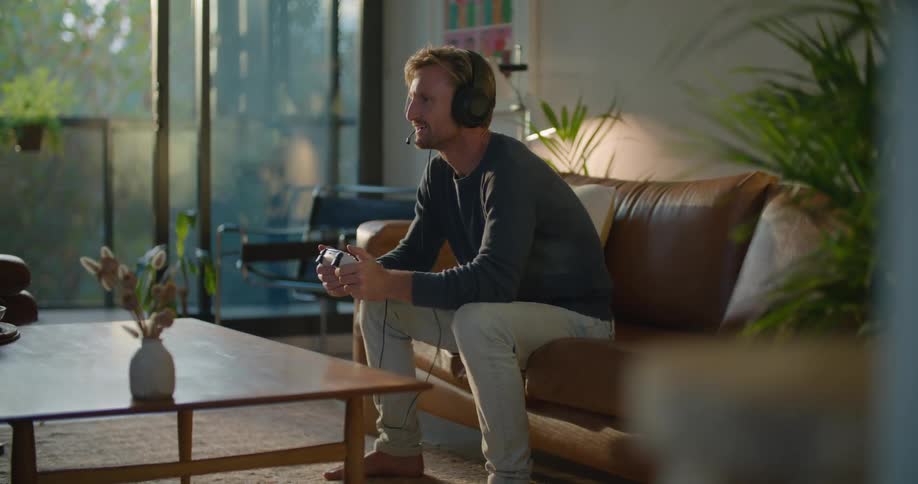 A man is playing video games on the couch