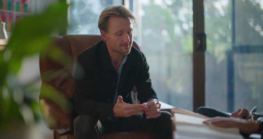 Two men are talking and sitting in their living room