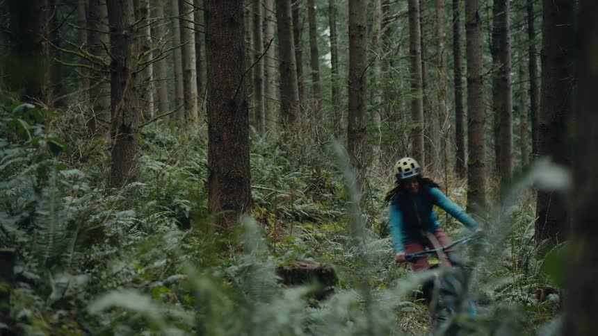 A woman rides his bicycle through the woods