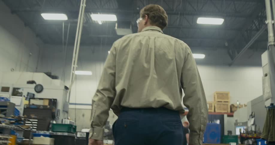 Boss walks through factory scanning working employees