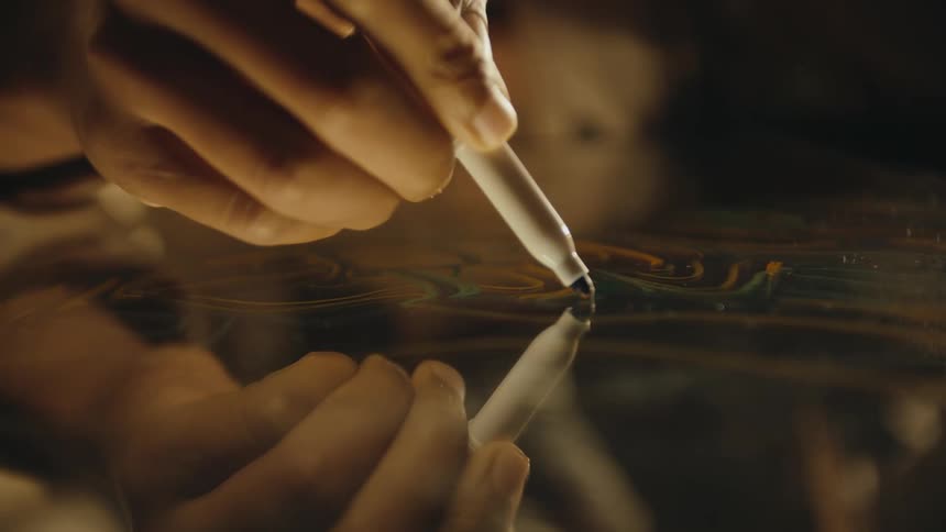 Close up of the hand of a designer drawing with a marker over glass