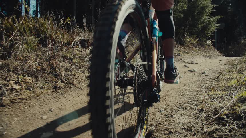 A person pedals hard to ride their mountain bicycle up a steep hill