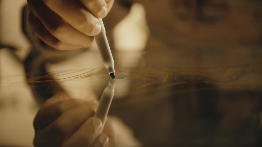 Person draws on mirror using marker