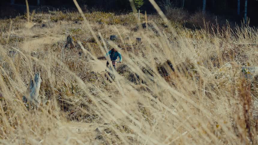 A person races their mountain bike on the trail