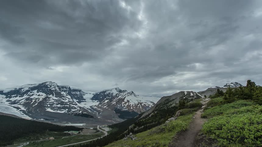 Heavy clouds move over a snow covered mountain range