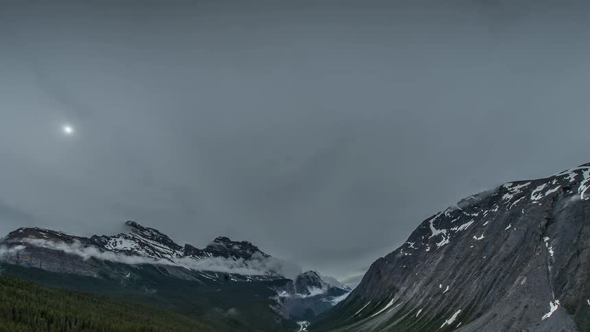 Fog rolls over some mountains on a cloudy day