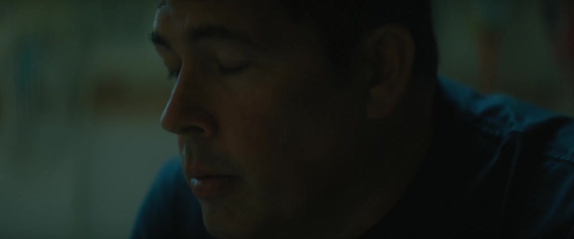 A man leans forward looking pensive and concerned