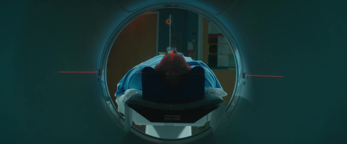 A patient gets scanned with a red laser light guide in an mri machine