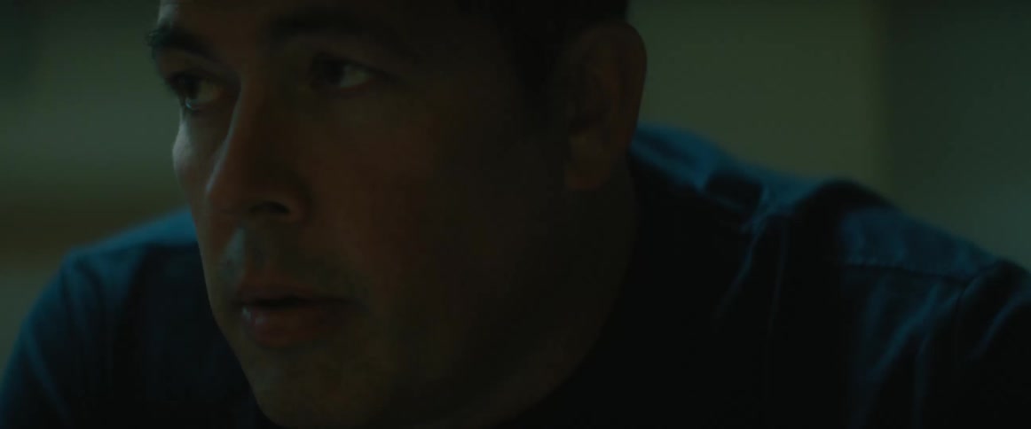 A man is sitting in a room and he looks very tired