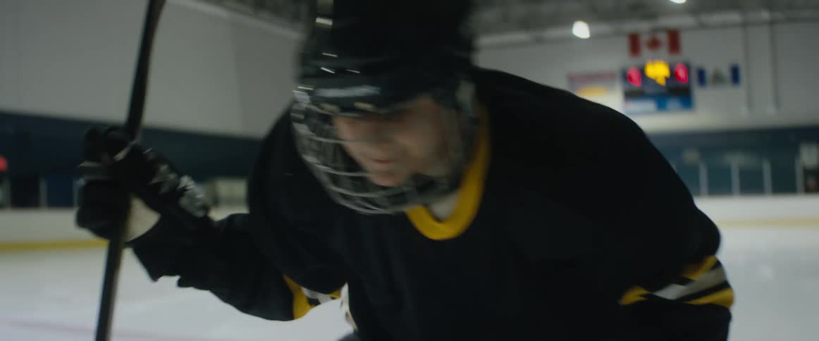 Ice hockey player stands up and skates away on an indoors ice rink
