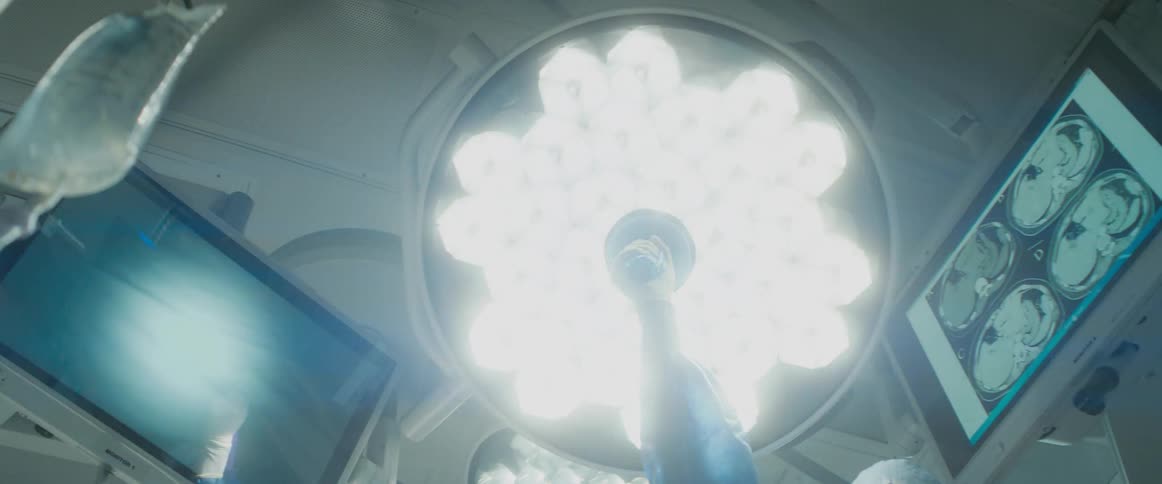 Someone turns the overhear light in an operating room and it shines very brightly