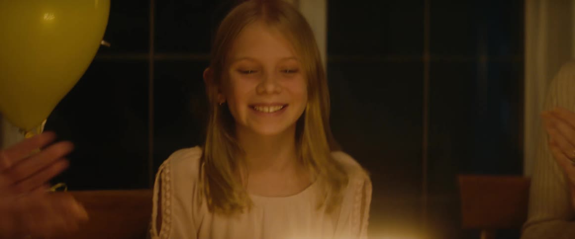 Family celebrates a little girl birthday at home with cake