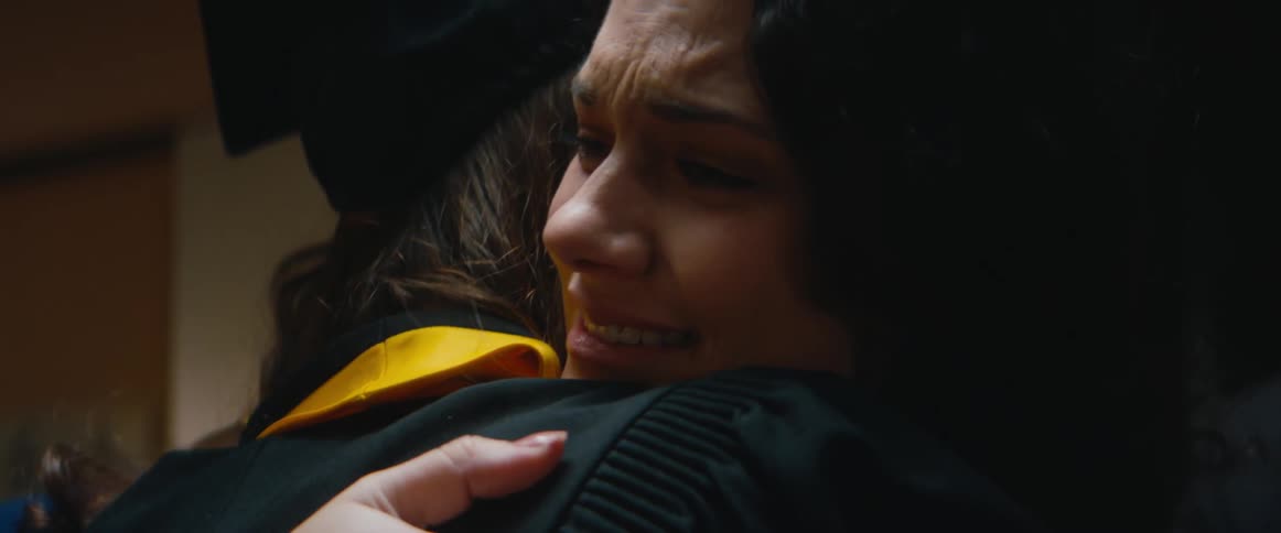 A graduate hugs a woman at the ceremony
