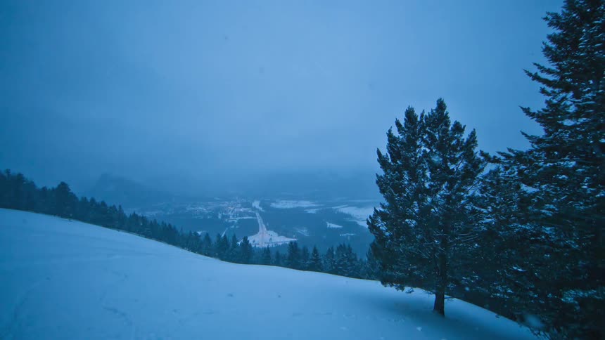 It is windy and snowing on this hillside