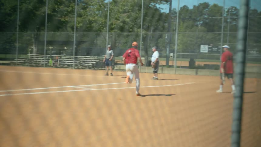 A man playing baseball runs to a base and then to home