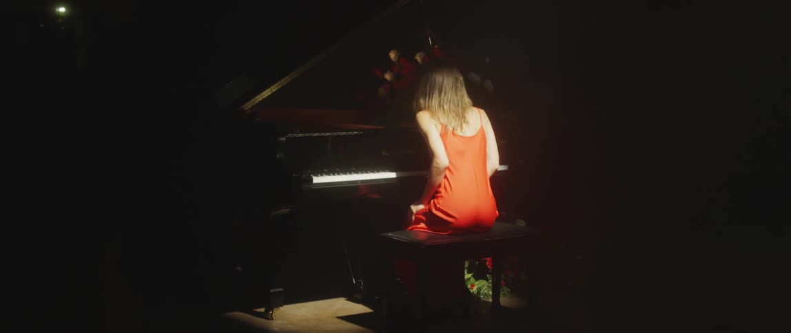 A woman is playing the piano in a room