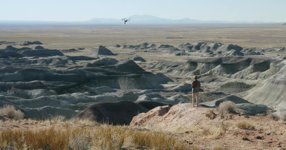 A man flies a drone over the canyon