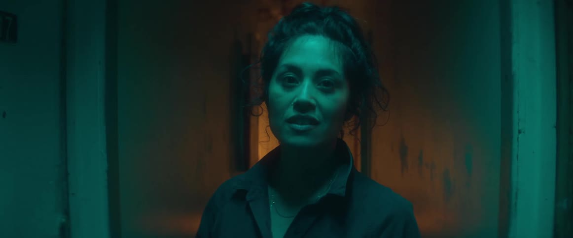 A woman walking through doorways pausing to turn her head and speak