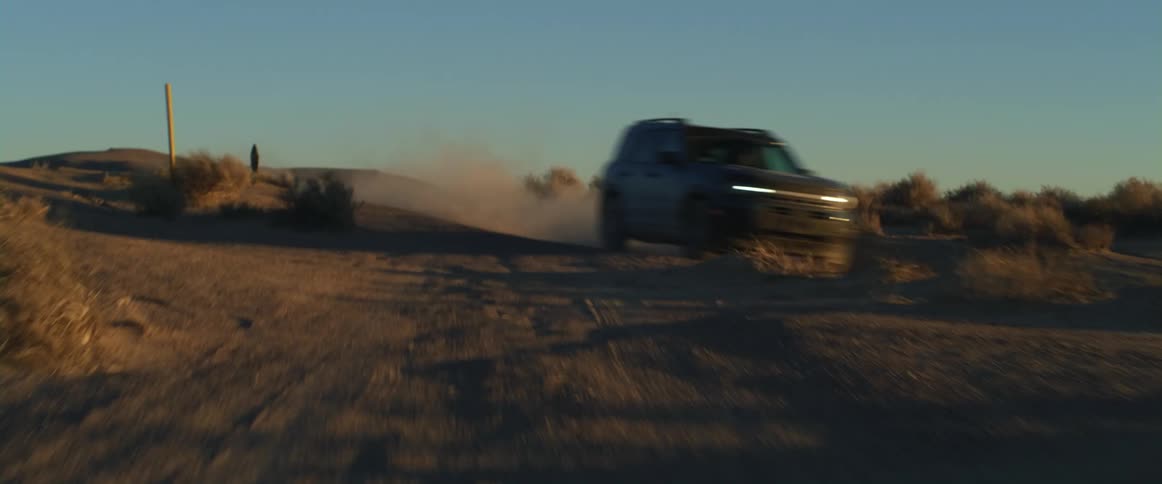 A vehicle races through the desert