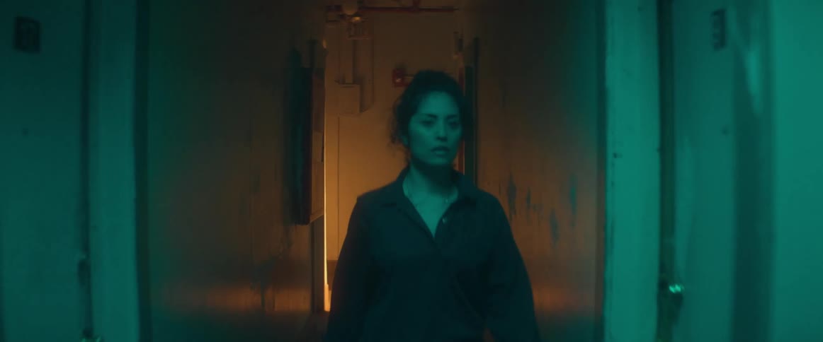 A woman is walking through a hallway in a building