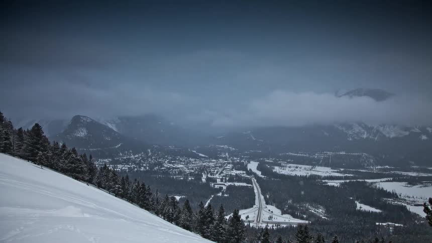 A snowstorm moves in over a town in a valley