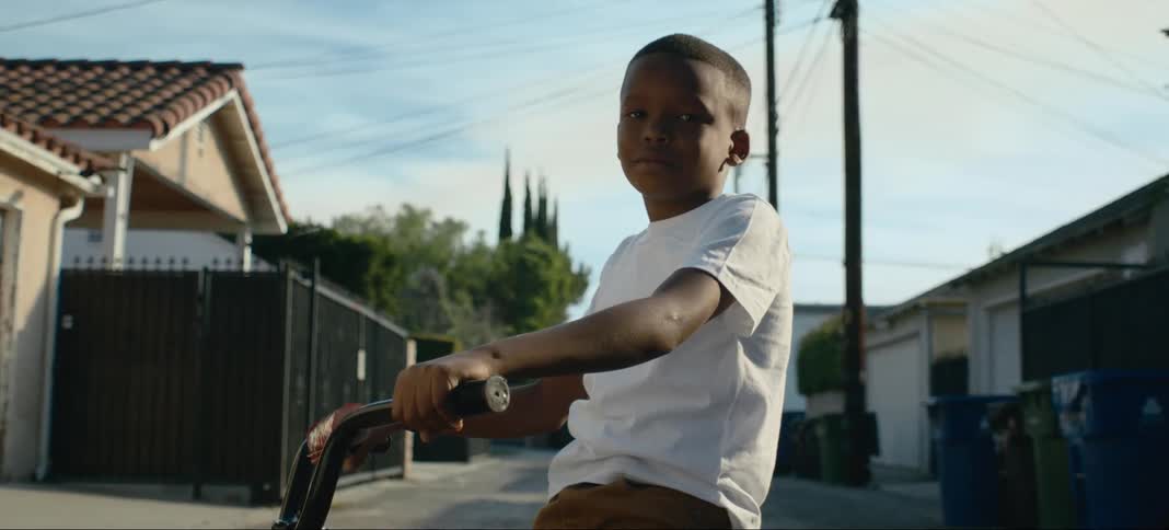 A child sits on his bicycle in the alley