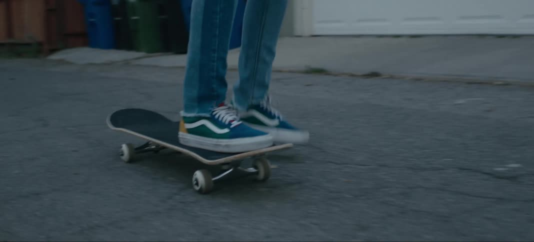 A person rides their skateboard down the alley