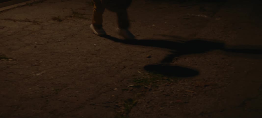 A person is dribbling the basketball at night