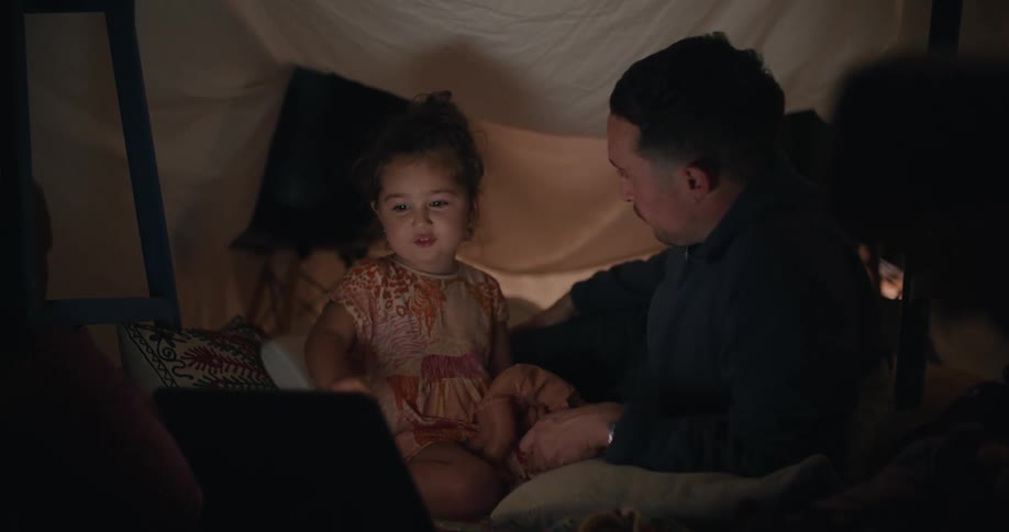 A father and daughter watch the laptop together