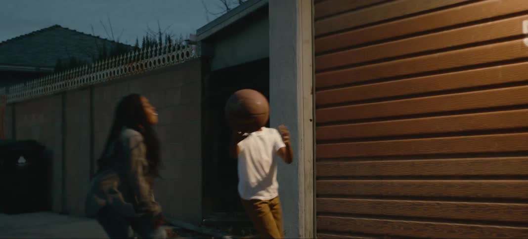 Two children are playing basketball in the alley