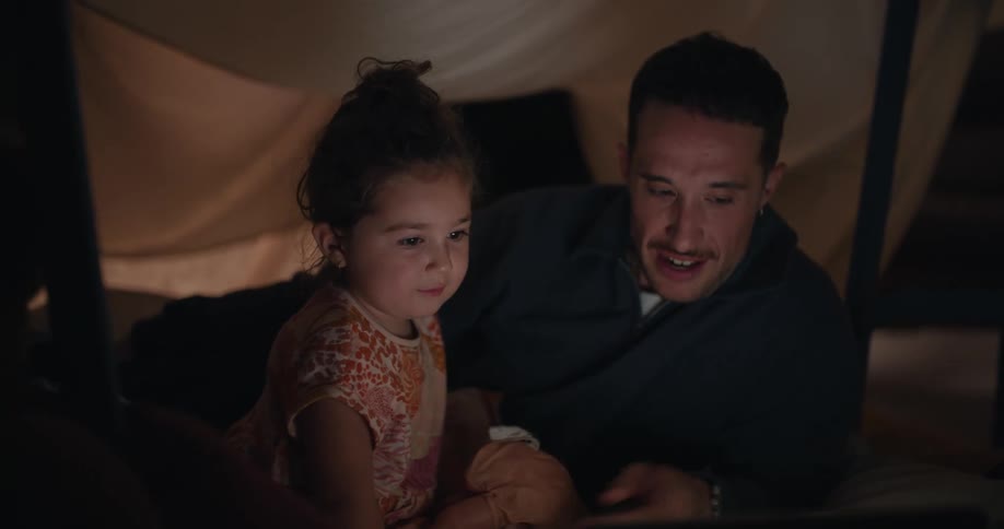 A man and child watch a laptop together