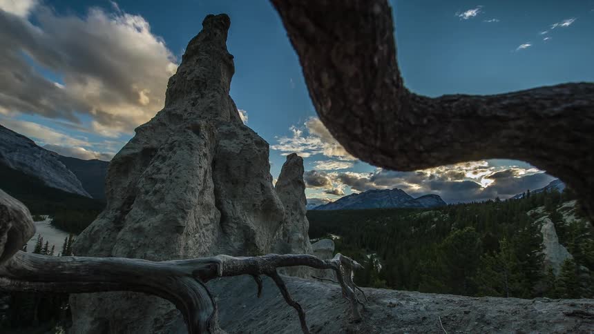 Clouds float over a tall rock formation