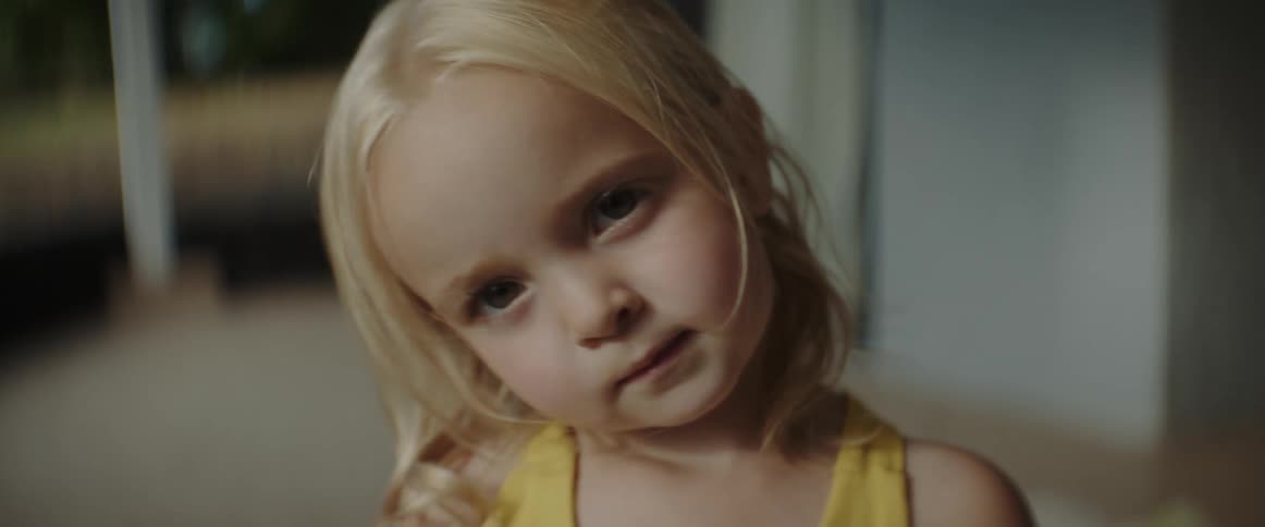 A young blond haired girl is making sad and funny faces