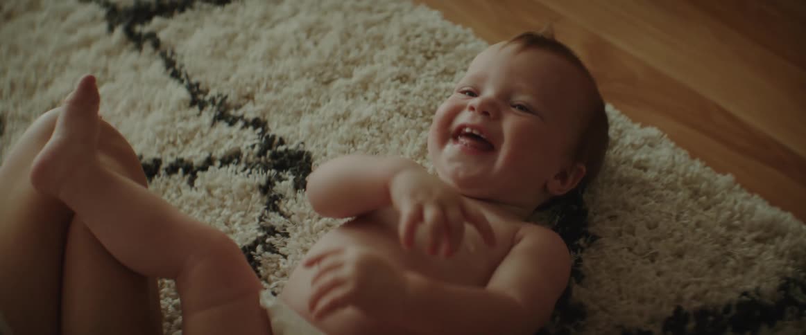 A baby laughs when its mother tickles its stomach