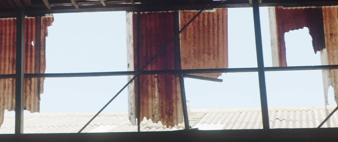 A row of broken windows in a dilapidated building during the day