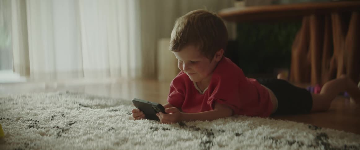 A child is playing a hand held video game indoors