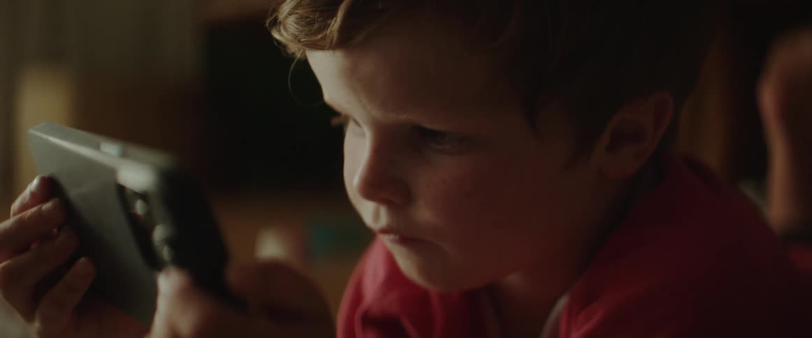 A child is intently looking at a phone screen
