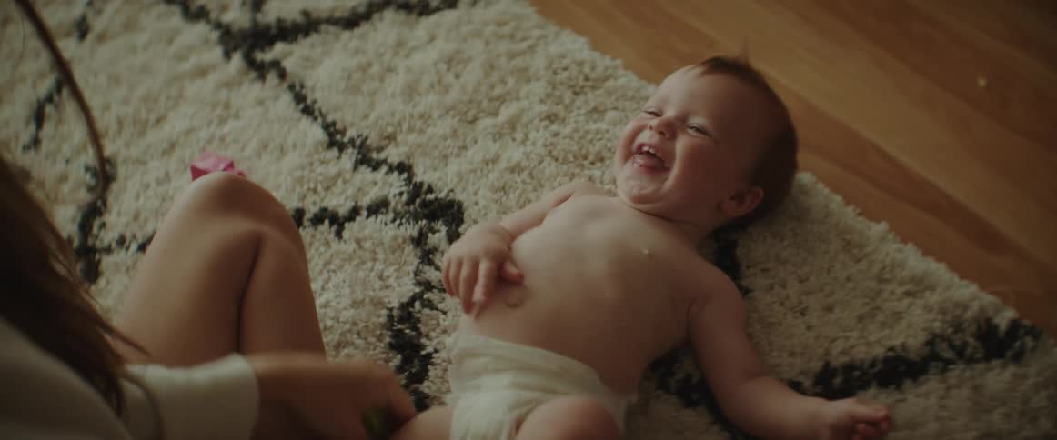 A mother is playing with her happy child indoors