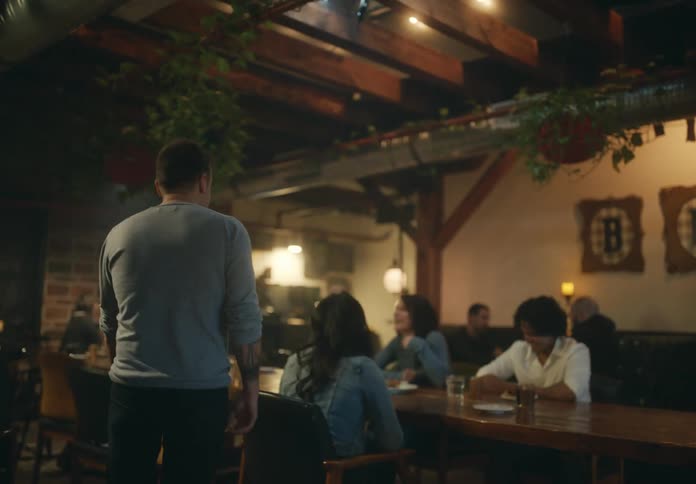A man enters the restaurant and sits down with friends