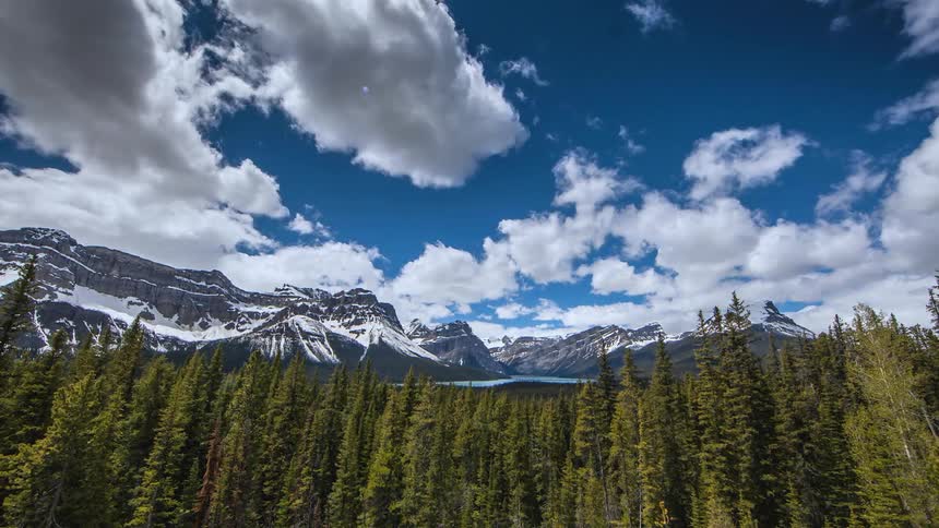 Clouds over a forest with a mountain in the distance
