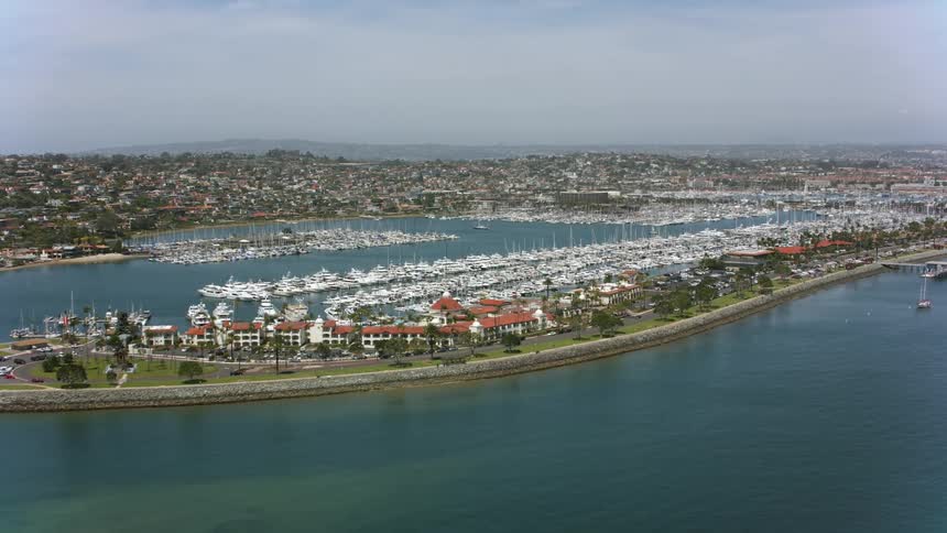 Coastal community on a peninsula and many boats in a marina under a cloudy sky