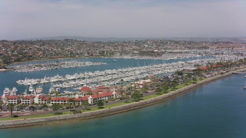 Coastal community on a peninsula and many boats in a marina under a cloudy sky