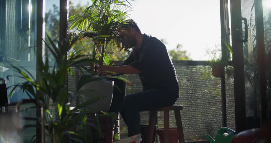 A man is planting a flower and sitting indoors