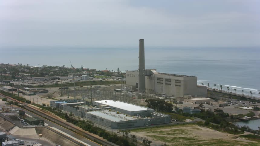 An aerial view of a large factory on the shore