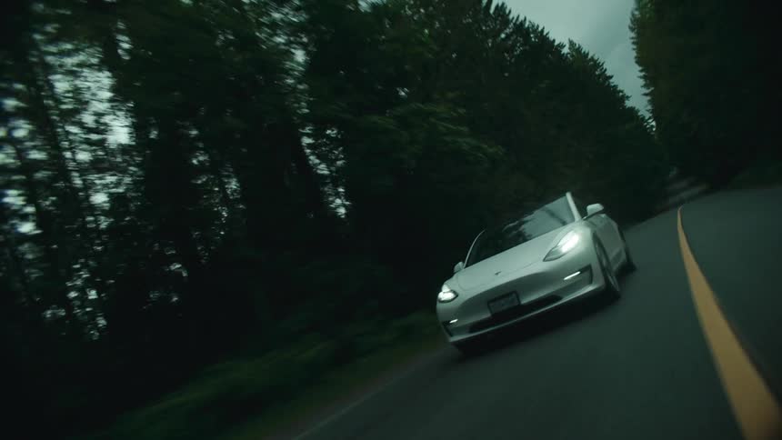 A car is driving on the long road