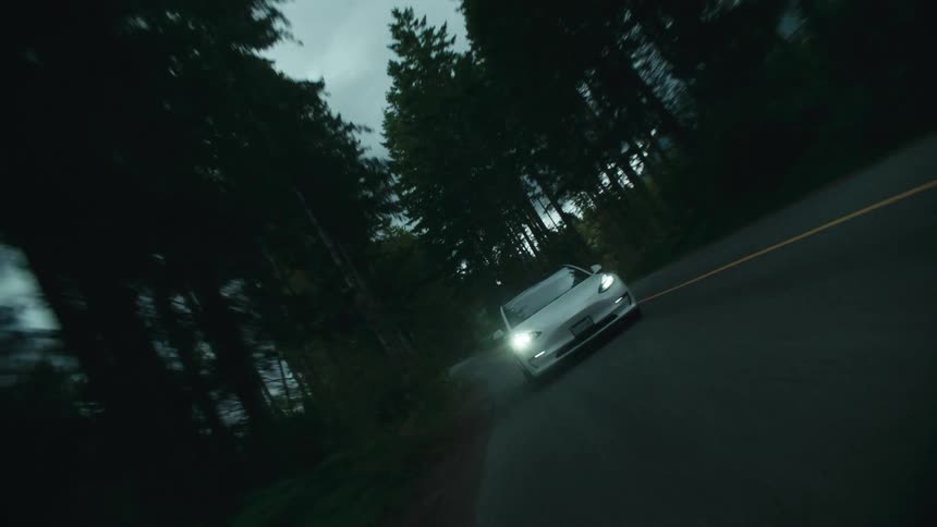A white car drives on the road